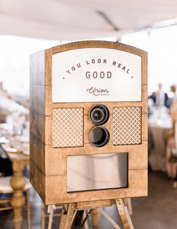 Union Station Photo Booth Photo booth camera encased in rustic wood finishes on top of a tripod stand